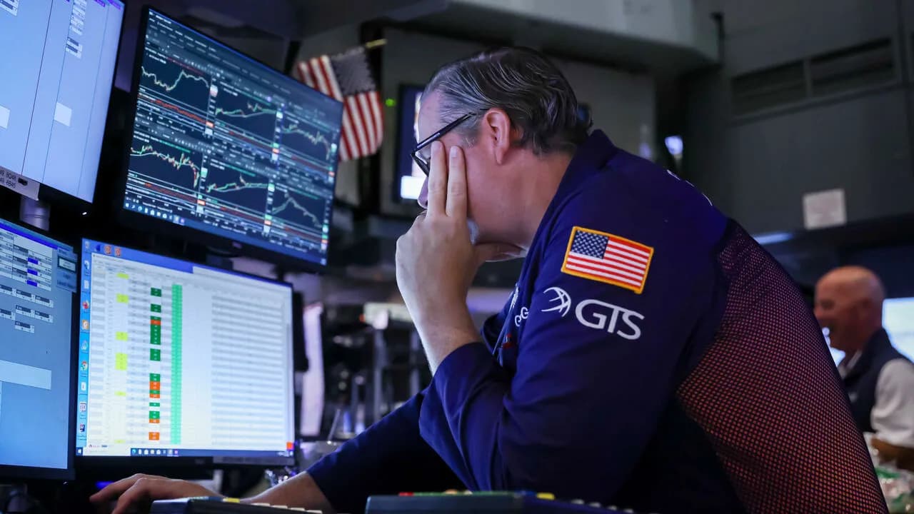 A trader looks at market screens on the floor of the New York Stock Exchange