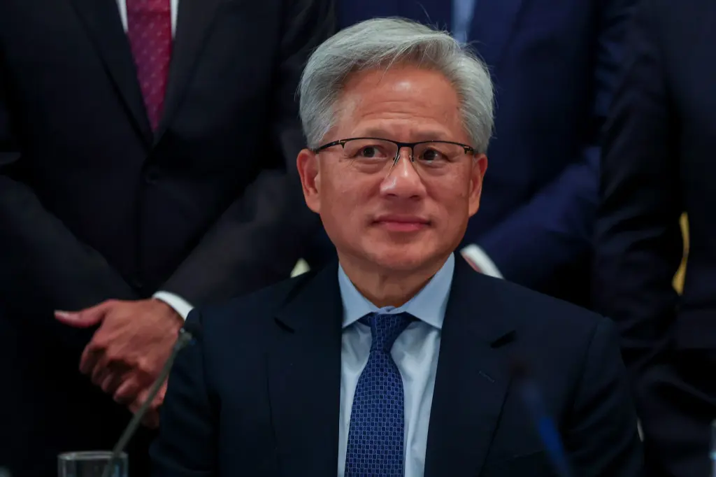 Nvidia CEO Jensen Huang smiles while seated at a meeting table