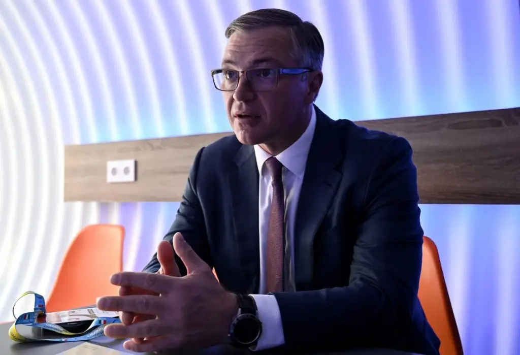 Yuriy Ryzhenkov, CEO of Metinvest, gestures while speaking during an interview, wearing glasses and a dark suit